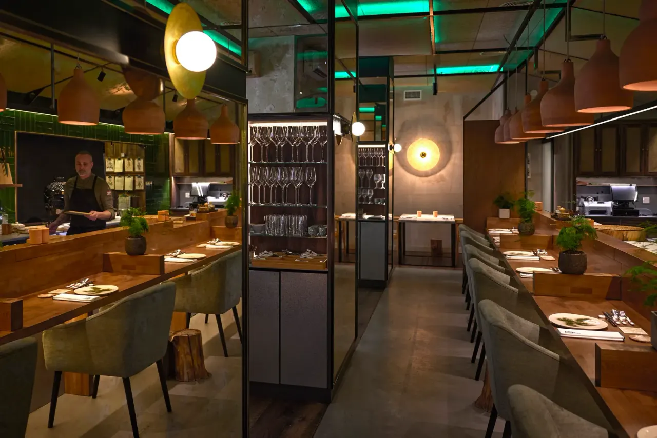 Vista completa del comedor de El Invernadero, con la retícula verde de la sala