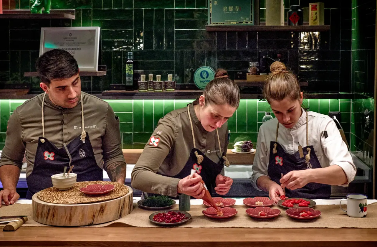 Tres cocineros emplatando a la vez en la cocina vista de El Invernadero